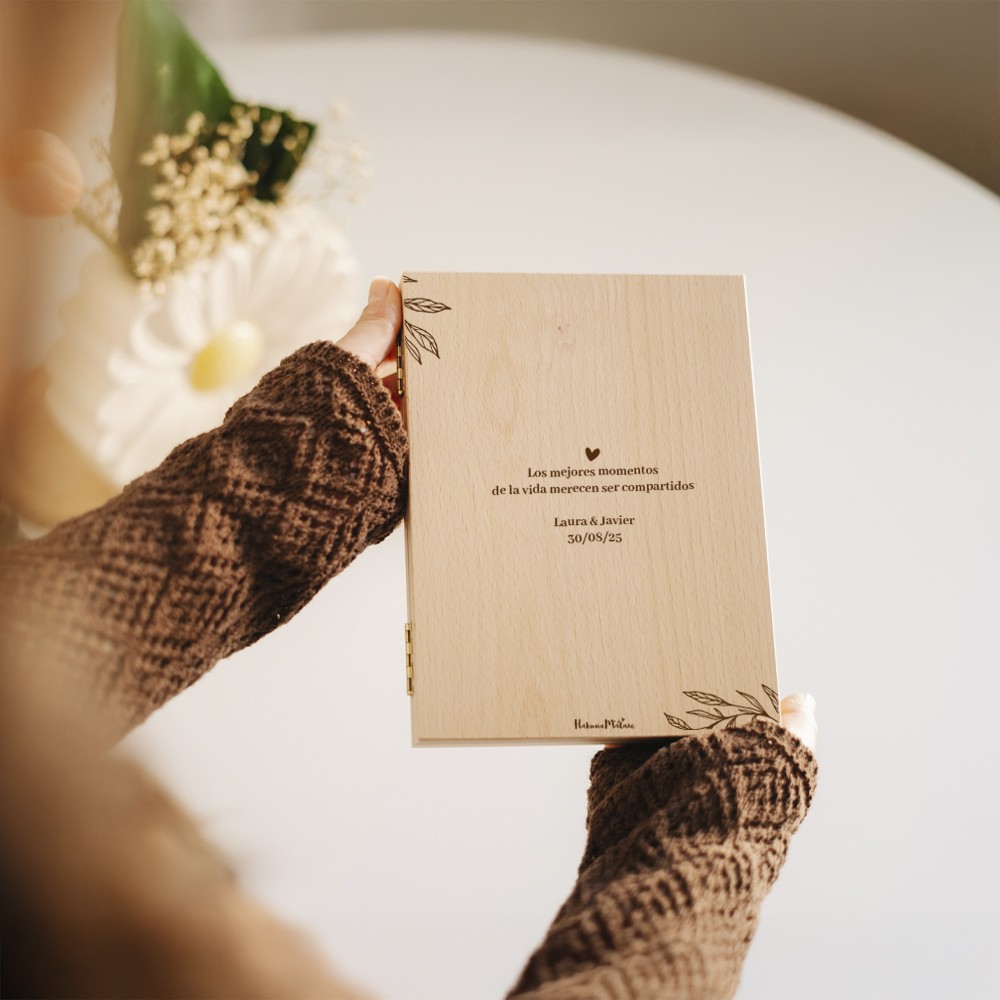 Vista del marco libro cerrado, con el diseño elegante de madera natural y la personalización en la portada.